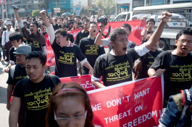 Reporters hold banners and shout slogans as they attend a demonstration march for press freedom in Yangon.